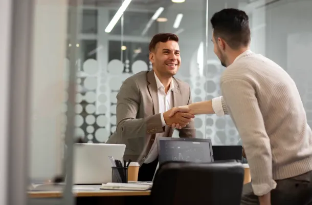 Dois rapazes se cumprimentando em uma sala de escritório